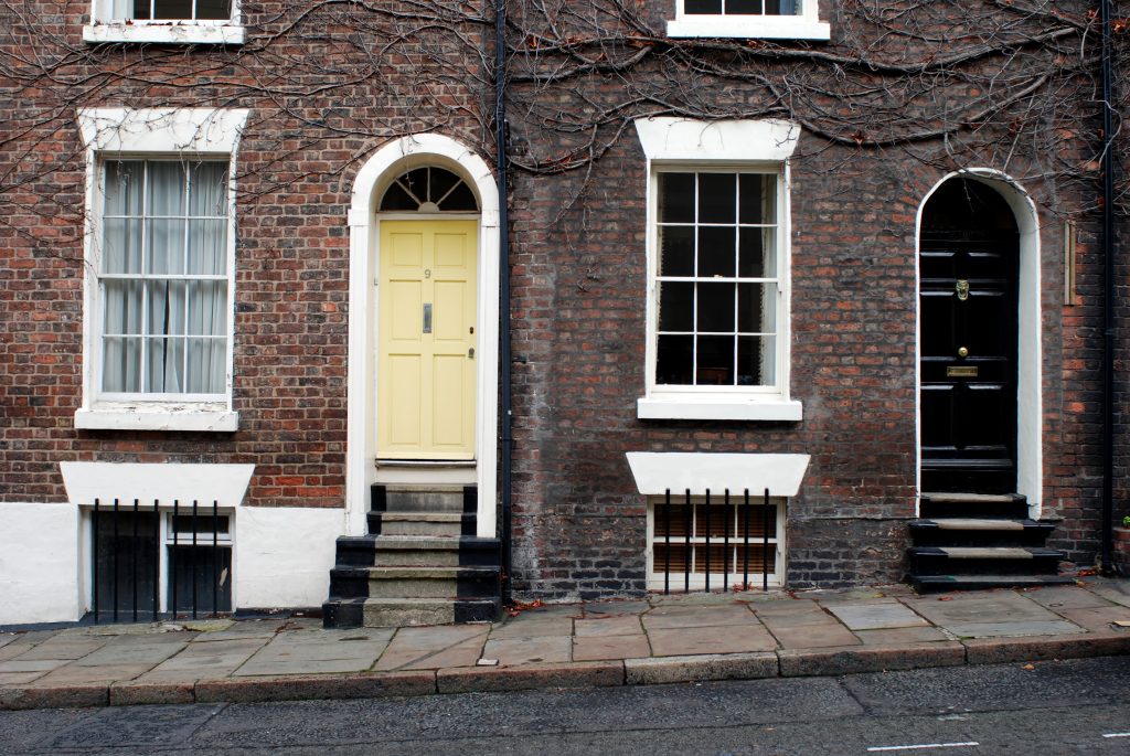 two houses with steps that have sash windows